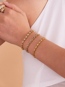 Détail d'un ensemble de bijoux infini et cœur doré avec zircons brillants au poignet