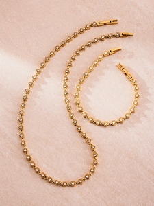 Vue détaillée de l'ensemble collier et bracelet cœur doré serti de zircons brillants