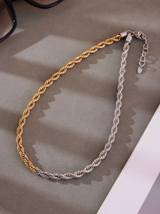 Détail d'une chaîne torsadée bicolore en acier avec fermoir mousqueton et logo