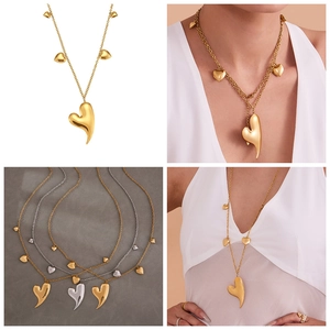 Détail de pendentifs en forme de cœur double couche sur une chaîne fine en or et argent