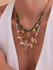 Macro detail of multi-layer ocean style necklace with octopus shell and clover pendants
