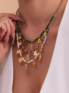 Detail of bohemian layered necklace with green beads and gold octopus octopus pendant