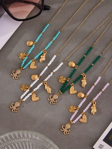 Detailed view of colorful beaded necklaces featuring octopus and seashell gold pendants