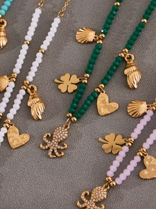 Detailed macro view of beaded octopus and clover pendants on handmade necklaces