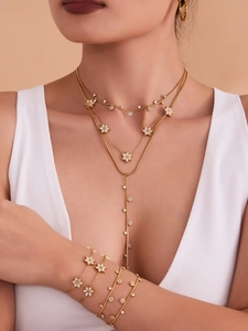 Detail of layered gold necklace with plum blossom pendants and zircon tassel