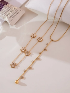 Detail of gold floral necklace with 5A zircon inlay and Y-shaped tassel pendant chain