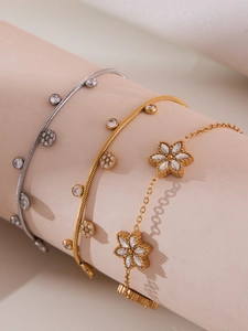 Detailed macro of gold and silver snake chains with zirconia flower and round pendants