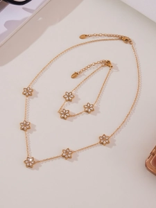 Macro shot of gold stainless steel flower jewelry set with sparkling cubic zirconia