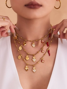 Vue détaillée du collier à plusieurs rangs avec breloques cœur dorées sur un mannequin
