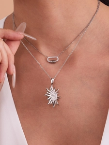 Vue détaillée de colliers superposés en argent avec pendentifs soleil et zircons 5A