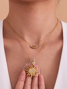 Détail d'un collier doré à double rang avec pendentif soleil et zircons sur un modèle