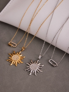 Gros plan sur pendentifs soleil et verrou avec zircons 5A sur chaînes plaquées or 18k