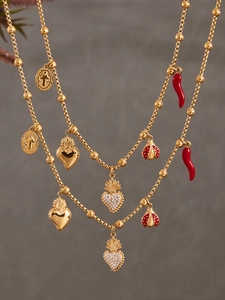 Détail du collier doré multi-rangs avec charms coccinelle piment et cœurs en cristal