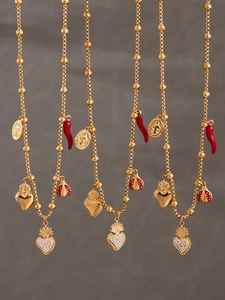 Détail de colliers dorés avec cœur en zircon, coccinelle rouge et pendentifs émail