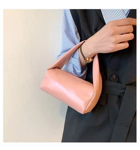 Detailed view of a pink mini cylindrical handbag with a smooth PU leather finish
