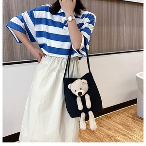 Detail of black canvas tote bag featuring a cute 3D plush bear and dual shoulder straps