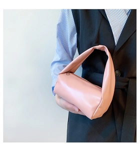 Close-up of pink minimalist cylindrical handbag with matte PU leather texture and top handle