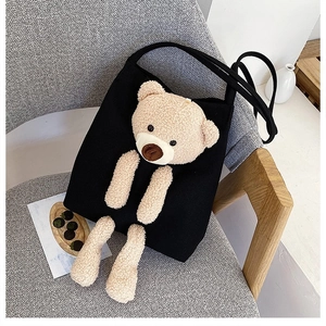 Detail of cute 3D plush bear on black canvas tote bag against minimalist interior decor