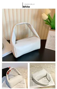 Detailed view of white minimalist handbag with soft knot handle and silver metal zipper