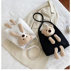 Detail of 3D teddy bear plush decoration on canvas tote bag showing soft texture