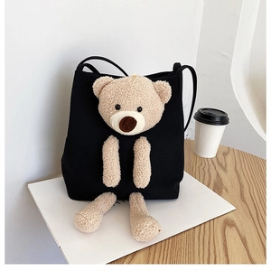 Detail of a 3D plush bear on a black canvas bucket bag with fine stitching