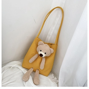 Detail view of the cute yellow canvas tote bag featuring a 3D plush bear ornament