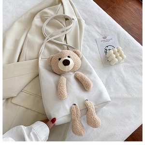 Detail view of large white canvas shoulder bag featuring a cute 3D plush teddy bear design