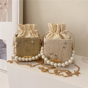 Chic woven bucket bag with pearl handle and floral embroidery in beige and apricot