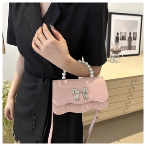 Detailed view of pink marble texture bag with pearl handle and silver butterfly charm