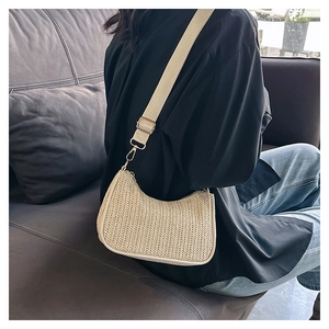 Detail of beige woven half-moon bag with V-shaped texture and adjustable canvas strap