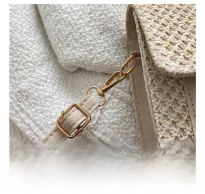 Détail du crochet en métal doré clair et bandoulière en cuir de sac en paille