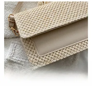 Détail de la texture paille et simili cuir avec boucles dorées d'un sac à main d'été