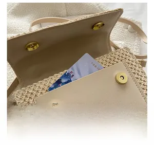 Détail du sac en paille tressée avec poche avant pour cartes et boucle magnétique dorée