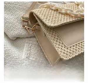 Vue macro détaillée montrant les coutures précises et la texture paille d'un sac à main beige