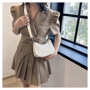Detail view of cream woven crescent crossbody bag with adjustable white wide strap