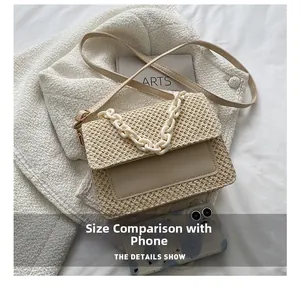 Détail du sac tissé avec chaîne en plastique et téléphone pour comparer la taille