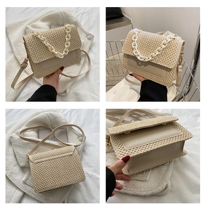 Vue détaillée d'un sac bandoulière en paille avec garniture en cuir beige et chaîne résine