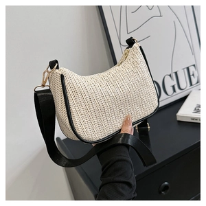 Detail of woven crescent tote with contrast black leather trim and gold hardware