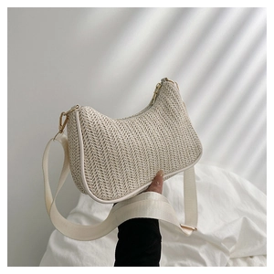 Detailed texture of straw woven tote with cream leather trim and gold hardware