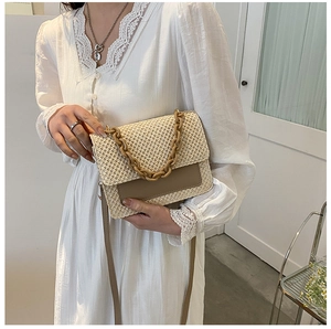 Détail du sac bandoulière beige tissé avec empiècement cuir brun et chaîne épaisse