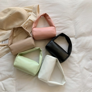 Minimalist cylinder handbag in five colors on textured fabric with a wide handle