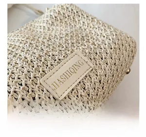 Détail du tissage en raphia et de l'écusson en cuir sur le sac bandoulière élégant