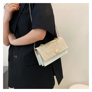 Détail du rabat en paille tressée et sac bandoulière en cuir blanc avec chaîne dorée
