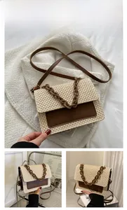 Vue détaillée du sac en paille tissée avec bandoulière en cuir brun et chaîne résine