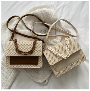 Détail du sac cabas en paille tressée avec chaîne en résine et rabat en cuir contrasté