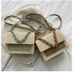 Détail de sacs à bandoulière en paille tissée avec poignées à grosse chaîne et rabat