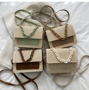 Détail de quatre sacs bandoulière tissés en différentes couleurs avec chaîne épaisse