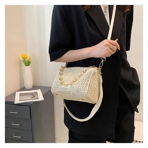 Détail du sac bandoulière tissé crème avec chaîne dorée et large bandoulière d'épaule