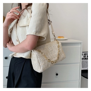 Détail du sac bandoulière tissé crème avec chaîne dorée et sangle en cuir