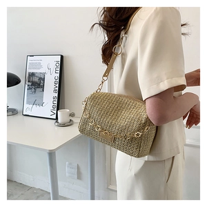 Detail of light brown woven texture crossbody bag with gold metal chain and leather strap
